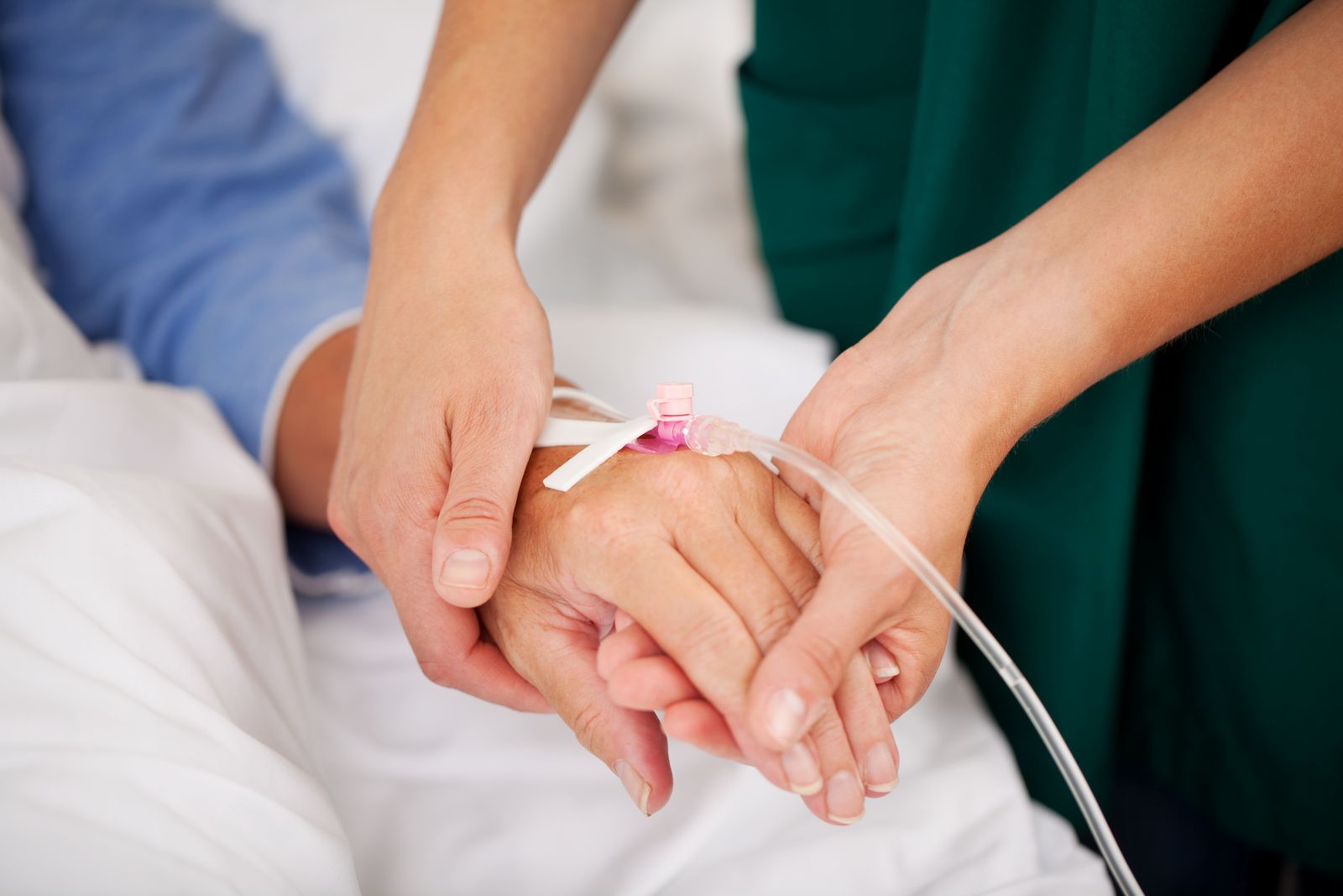 iv therapy nurse holding womans hand
